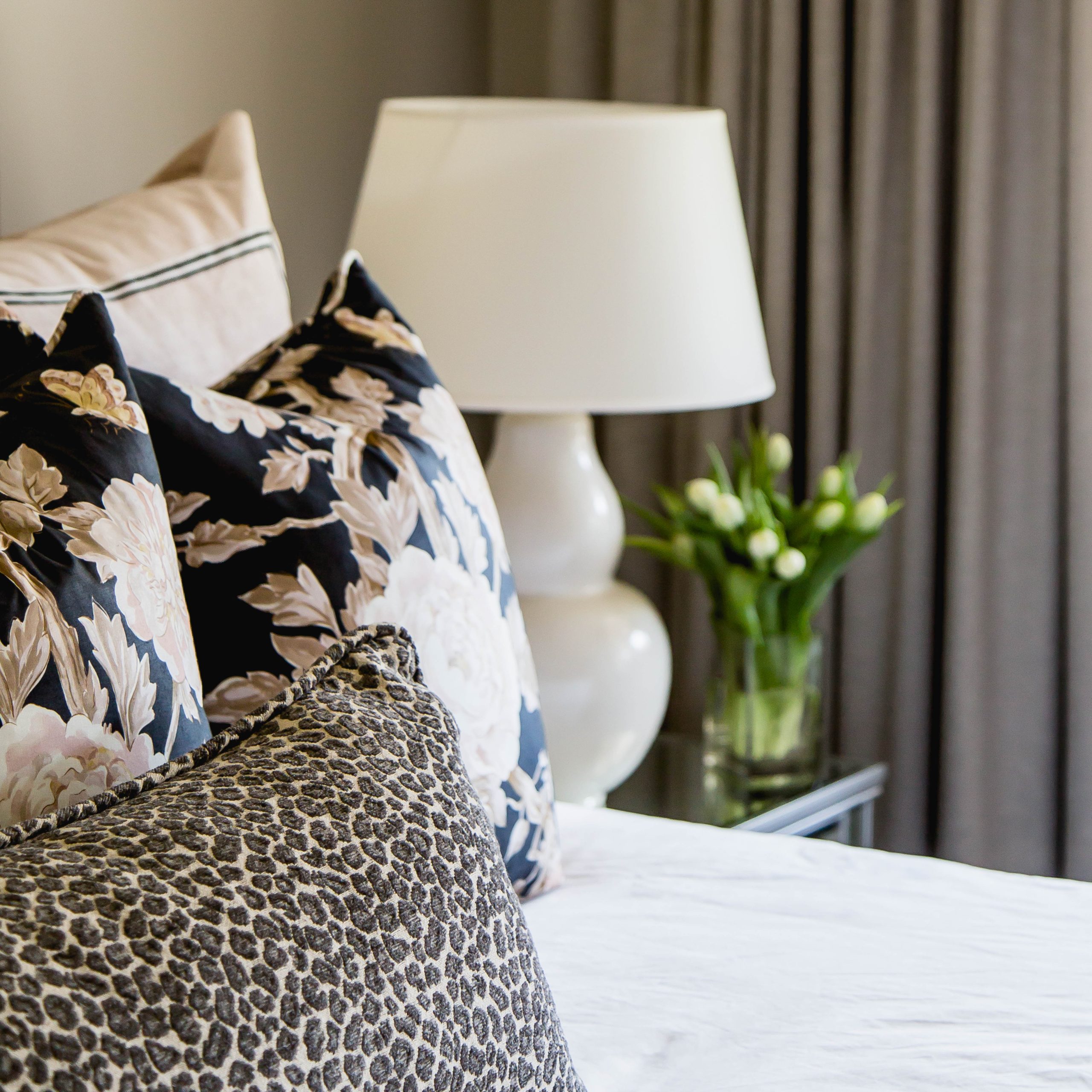 Details of master bedroom pillows; pink florals, pink velvet and a leopard print.