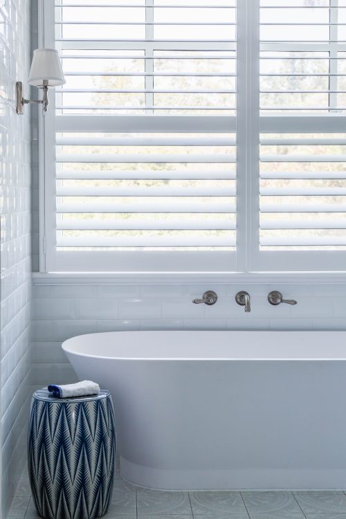 A Hamptons inspired bathroom with subway tiles and patterned floor.